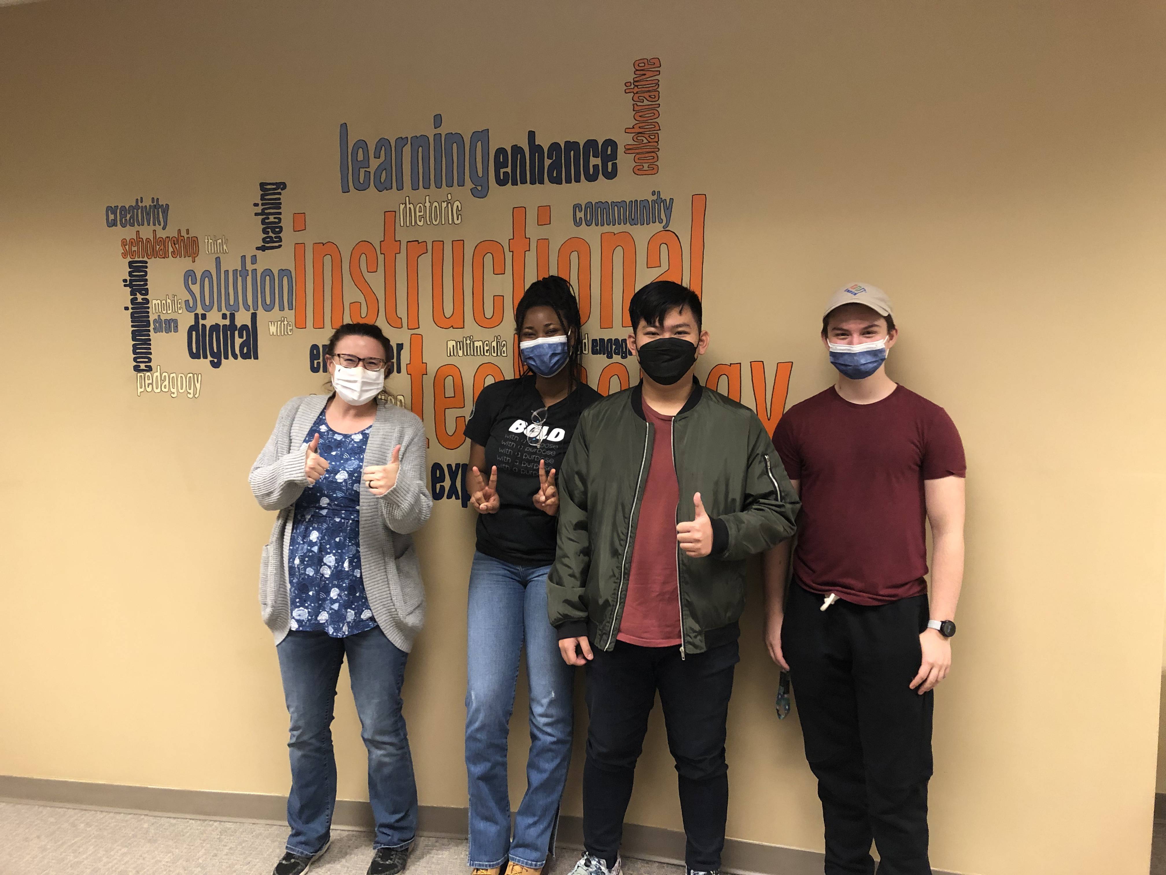Wooster computer scientists posing in front of the instructional
            technology word cloud in Taylor 205